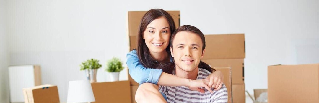 man and women sitting in front of moving boxes