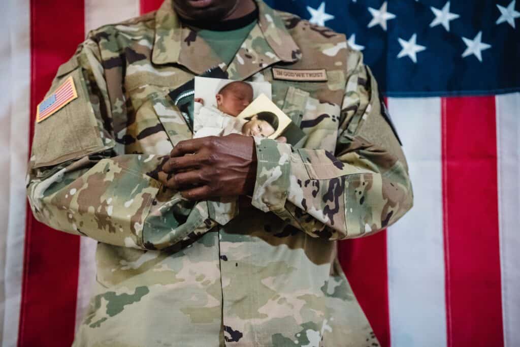 service person in uniform holding pictures of children - va loan qualifications